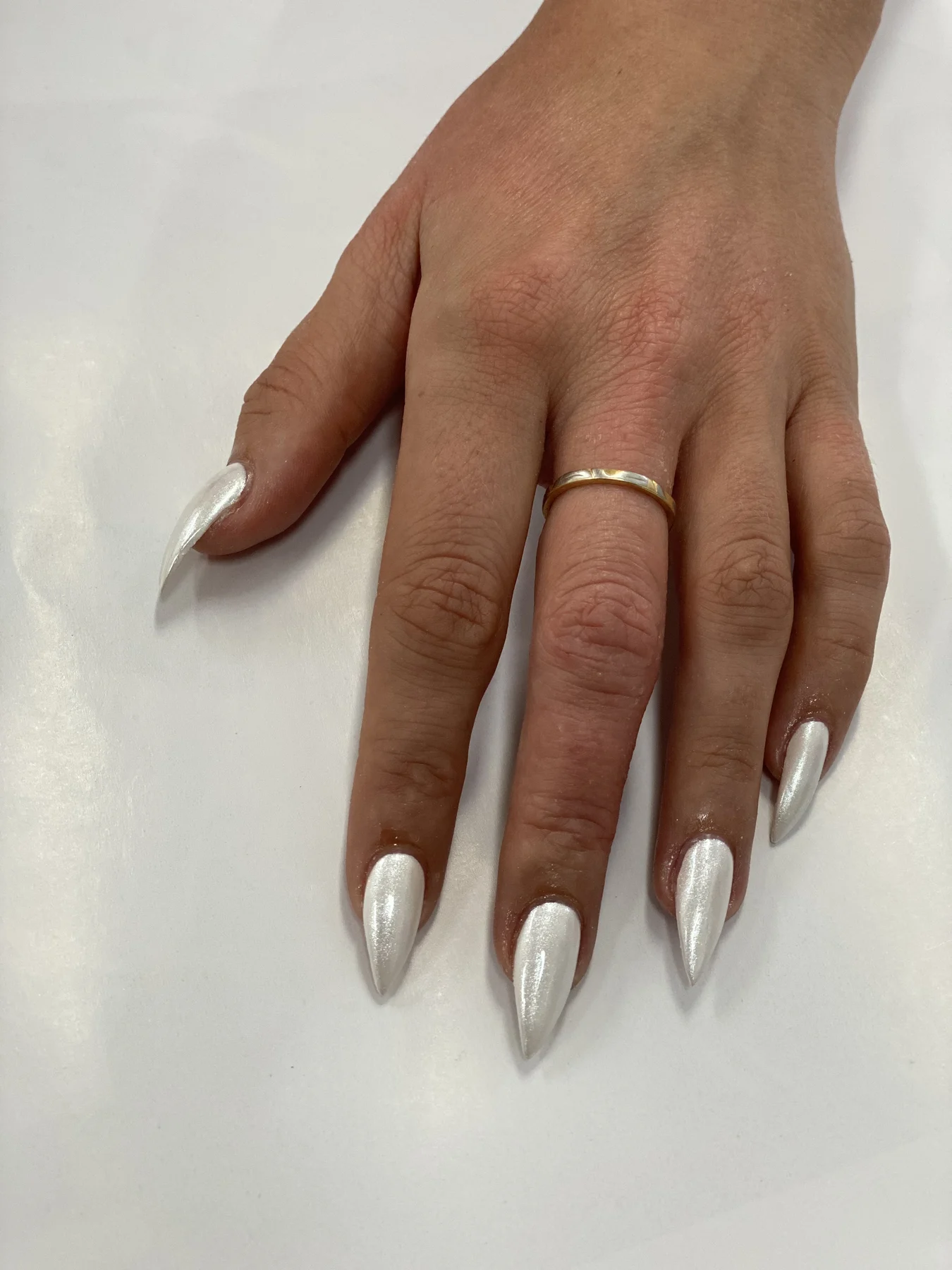 White-chrome stiletto nails with gold band