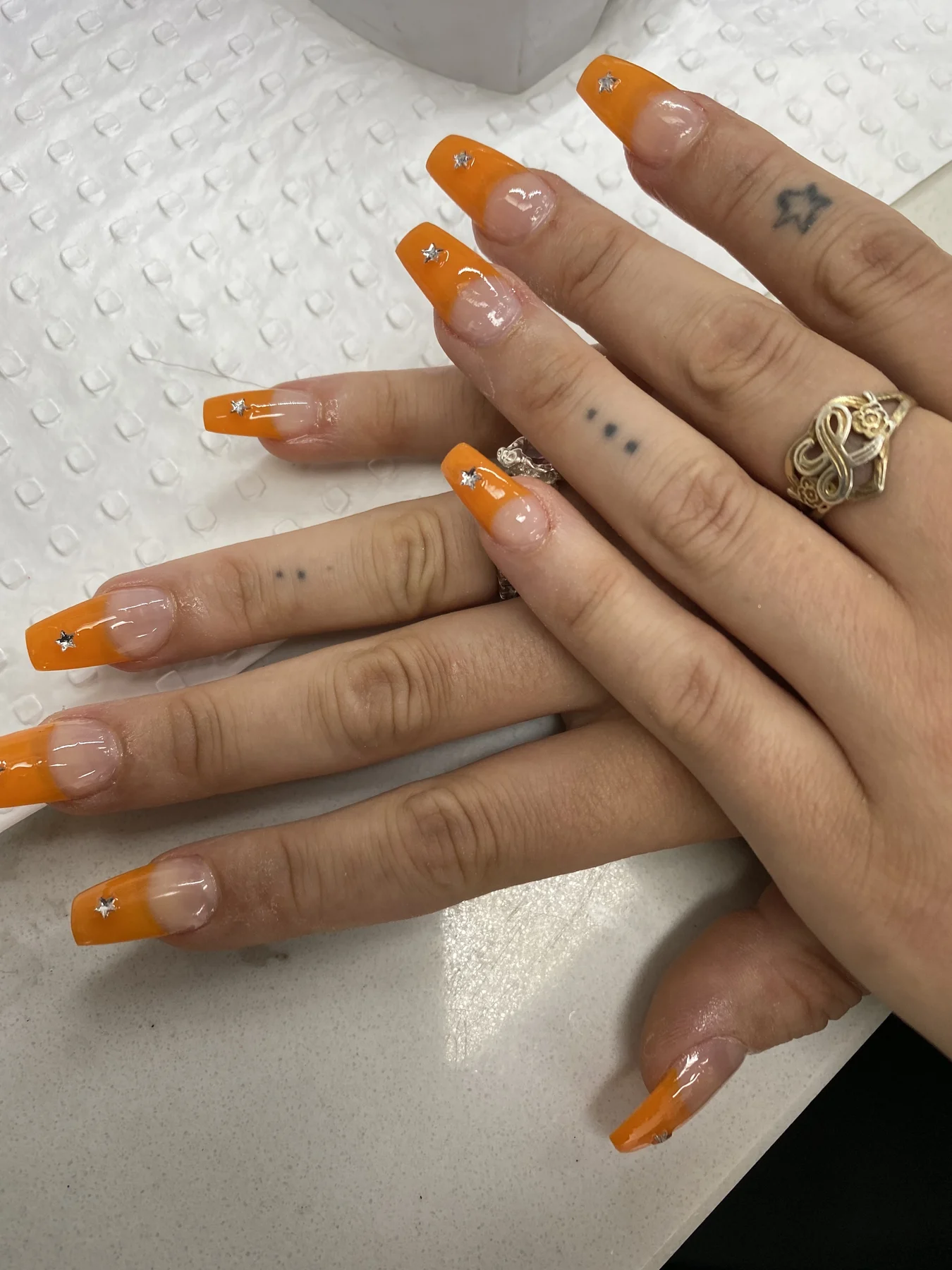 Long orange french nails with gemstone accents