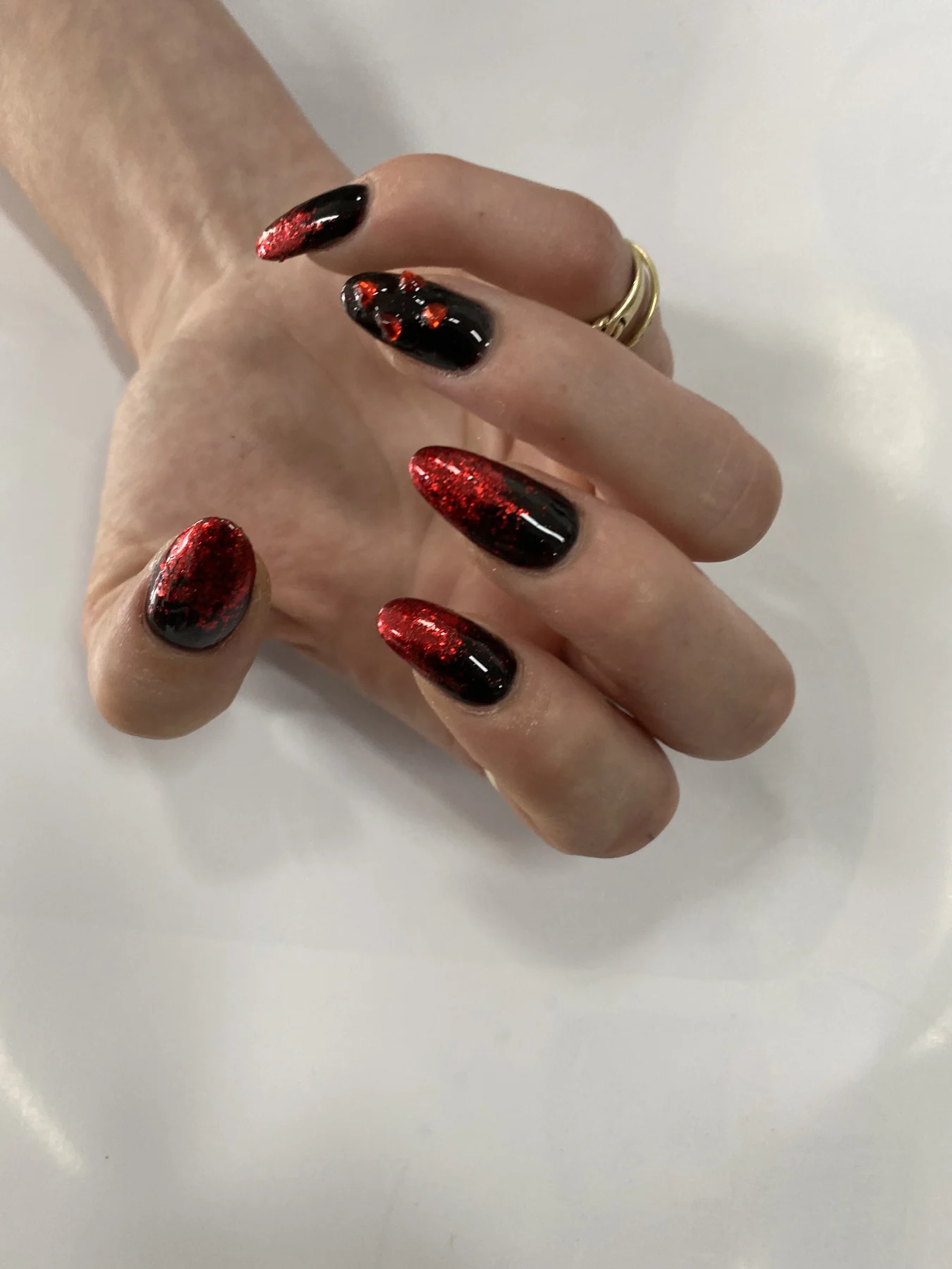 Red-glitter and black ombre nails on white towel