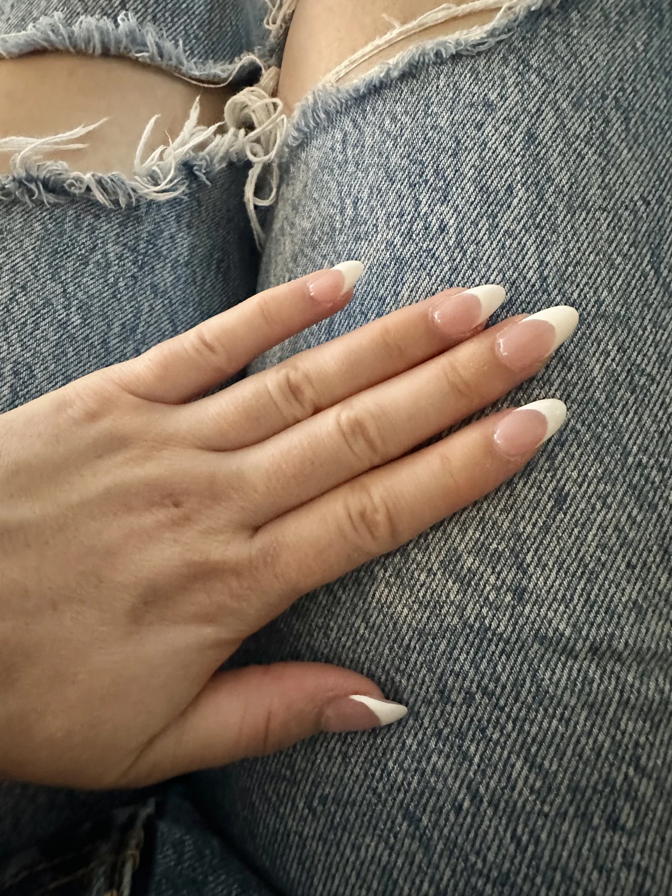 Cream-white nails on ripped blue denim