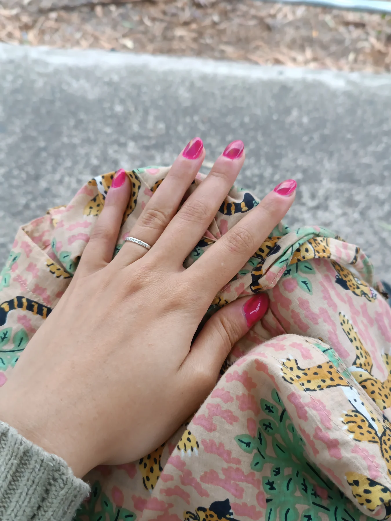 Bright-pink nails on floral fabric